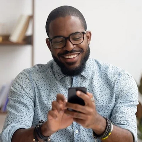 Smiling black man using his cell phone